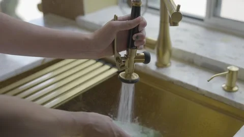 Kitchen sink faucet gold cleans dish Stock Footage 313908955