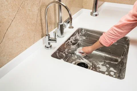 Kitchen sink in foam while washing by female hands Stock Photos