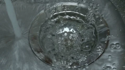 Kitchen sink, water flows from the tap into the hole in the sink. Stock Footage 96601096
