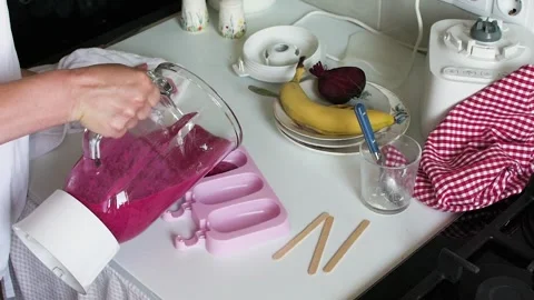 In the kitchen, someone blends strawberries, bananas, and beets to make ice.. Stock-Footage 338408053