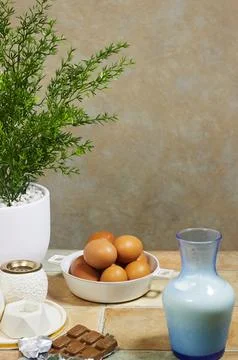 Kitchen Still Life With Brown Eggs, Milk Carafe, Chocolate and Potted Plant on T Stock Photos