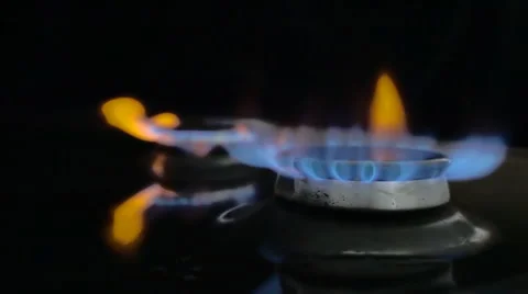 In the kitchen stove ignited the fire in the two burners on a black background Stock Footage 64686075