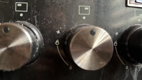 Kitchen stove knobs close up at home with hand adjusting control, changing heat 库存影片 337104778