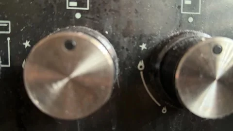 Kitchen stove knobs close up at home with hand adjusting control, changing heat 库存影片 337104782