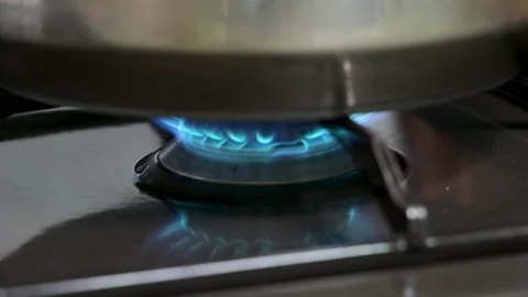 The kitchen stove is lit, and the flame emits a blue light. Stock Footage 257374503