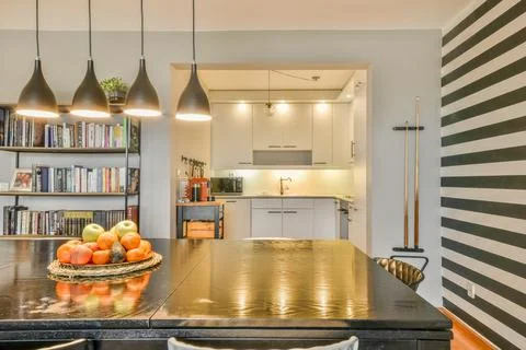 A kitchen with a table and a bowl of fruit Stock Photos