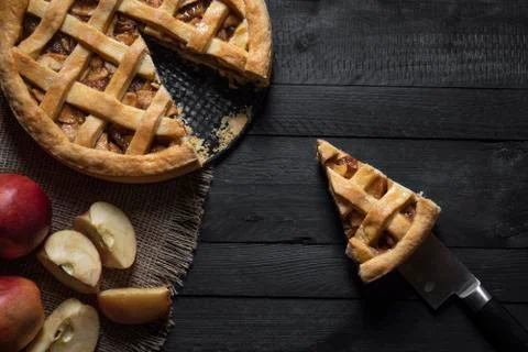 Kitchen table with an apple pie and a slice. Above view. Traditional sweet pi Stock Photos