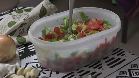 Kitchen table with a bowl of tomato and lettuce salad, and a tray of freshly Stock Footage 137045477