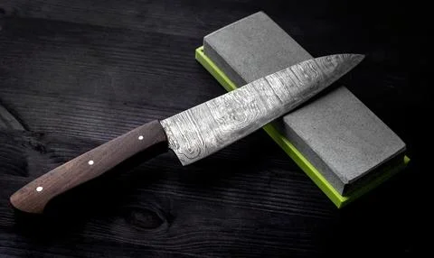 Kitchen Table Displays Large Knife With Sharpening Stone Stock Photos