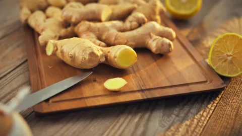 On the kitchen table fresh ginger rhizomes display their brown roots burstin Stock Footage 331365979
