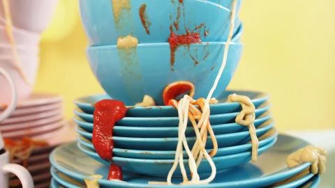 Kitchen table full of dirty dishes, isolated yellow background. close up. Studio Stock Photos