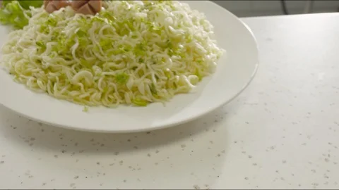 In the kitchen, on the table puts a plate of noodles, slices of sausage and Video stock 86573678