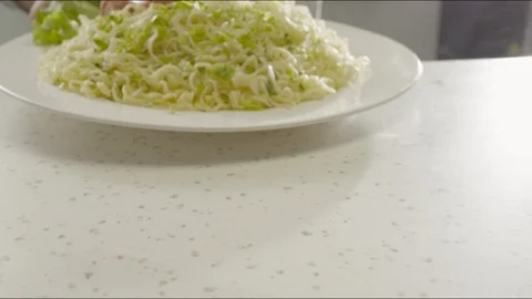 In the kitchen, on the table puts a plate of noodles, slices of sausage and Video stock 86573756