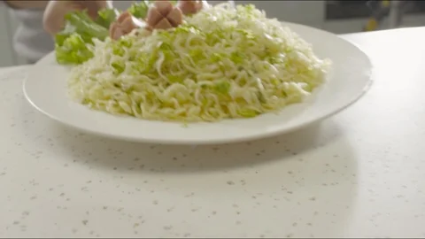 In the kitchen, on the table puts a plate of noodles, slices of sausage and Video stock 86573768