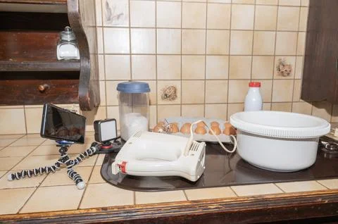 Kitchen table setting up for a cooking video, with a smartphone on a tripod Stock Photos