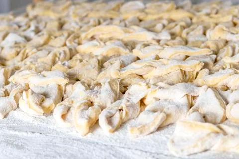 Kitchen table. Sprinkled with flour. On it are dough products. Brushwood. Clo Stock Photos