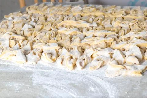 Kitchen table. Sprinkled with flour. On it are dough products. Brushwood. Clo Stock Photos