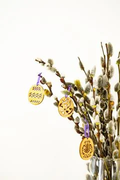 On the kitchen table wooden Easter eggs are placed on the branches Stock Photos