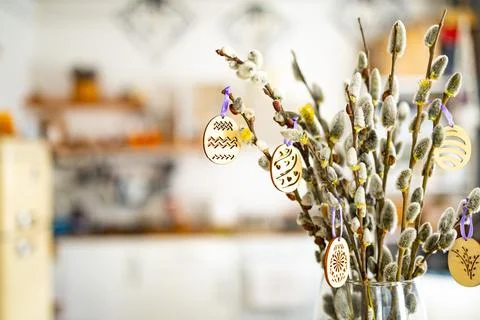 On the kitchen table wooden Easter eggs are placed on the branches Stock Photos