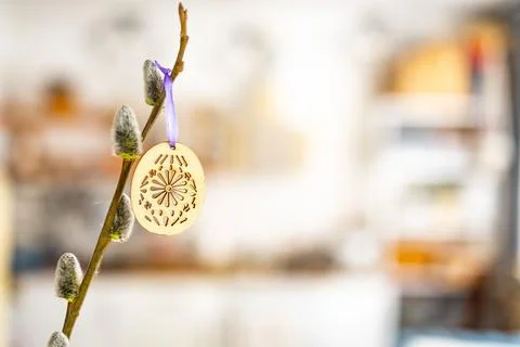 On the kitchen table wooden Easter eggs are placed on the branches Stock Photos