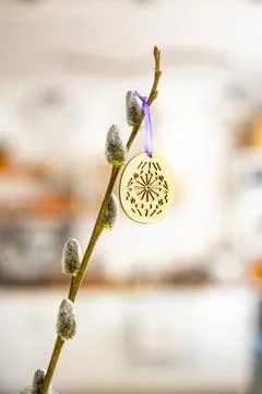 On the kitchen table wooden Easter eggs are placed on the branches Stock Photos
