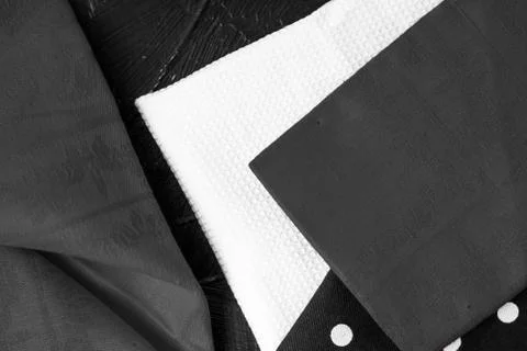Kitchen textile on black rustic wooden background, napkin and towel set, fold Stock Photos