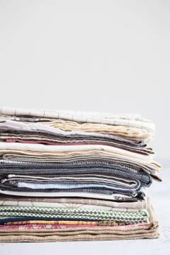 Kitchen textile. stack of fabrics in different colors and textures, close-up. Stock Photos