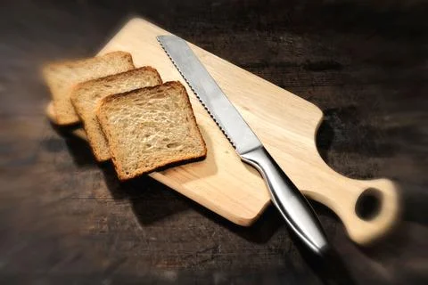 Kitchen things, bread with bread knife on wooden cutting board Stock Photos