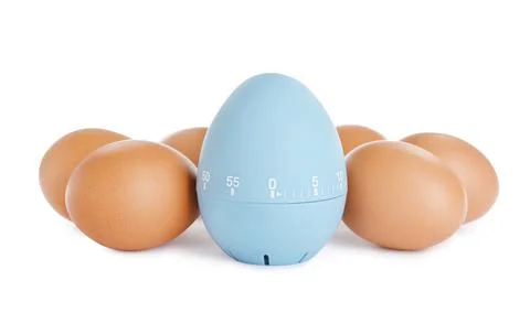 Kitchen timer and chicken eggs on white background Foto stock