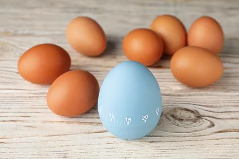 Kitchen timer and eggs on white wooden table Foto stock