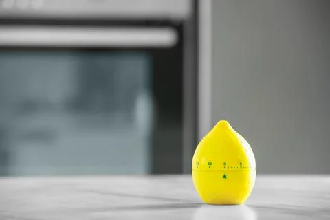 Kitchen timer in shape of lemon on light grey table indoors. Space for text Stock Photos
