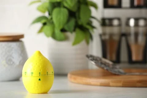 Kitchen timer in shape of lemon on white table. Space for text Stock Photos