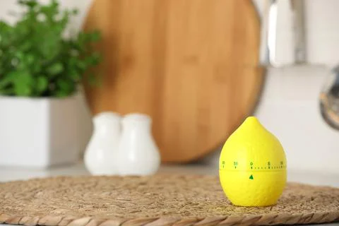 Kitchen timer in shape of lemon on wicker mat indoors. Space for text Stock Photos