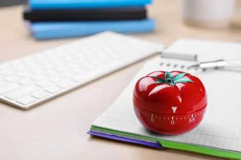 Kitchen timer in shape of tomato and notebook on wooden table, space for text Stock Photos