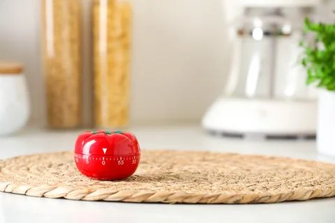 Kitchen timer in shape of tomato on light table indoors. Space for text Stock-Fotos