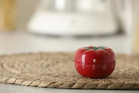 Kitchen timer in shape of tomato on table indoors. Space for text Foto stock