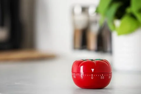 Kitchen timer in shape of tomato on white table indoors. Space for text Stock Photos