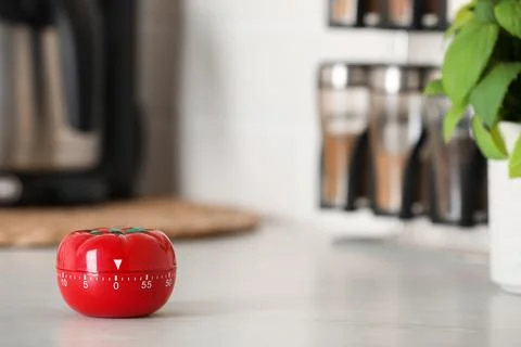 Kitchen timer in shape of tomato on white table indoors. Space for text Stock Photos