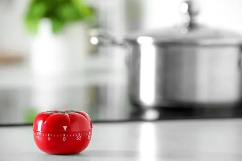 Kitchen timer in shape of tomato on white table indoors. Space for text Stock Photos