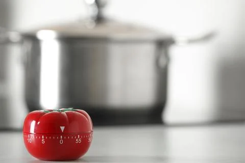 Kitchen timer in shape of tomato on white table indoors. Space for text Stock Photos