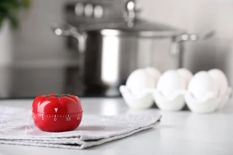 Kitchen timer in shape of tomato on white table indoors. Space for text Foto stock