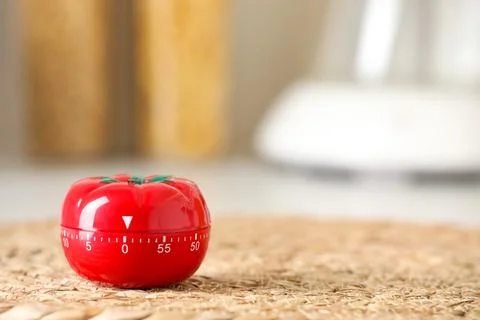 Kitchen timer in shape of tomato on wicker mat indoors. Space for text Stock-Fotos