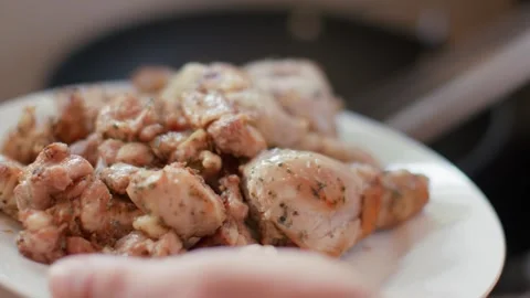 Kitchen tongs remove large pieces of fried chicken from the pan and the man 库存影片 256058362