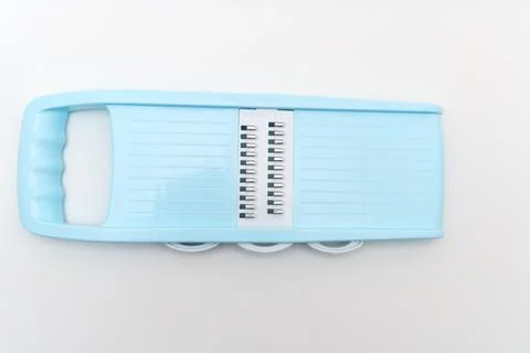 Kitchen tool for grating and slicing vegetables and cheese in light blue colo Stock Photos