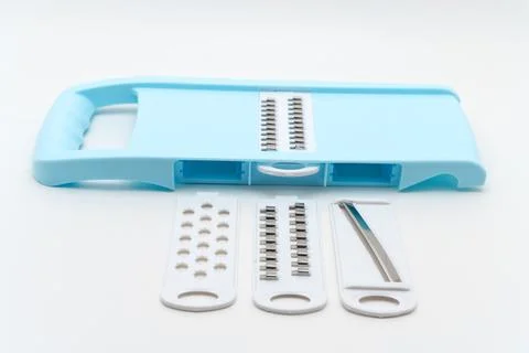 Kitchen tool for slicing and grating food items placed on a white surface Stock Photos