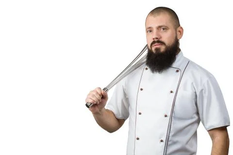 Kitchen tools concept. Cook with serious face holding whisk on the shoulder.  Stock Photos