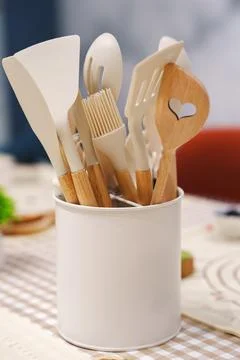 Kitchen tools stored in a white container on a table Stock Photos