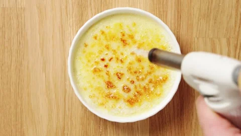 Kitchen torch caramelizes sugar on crema catalana. Stock Footage 345273503