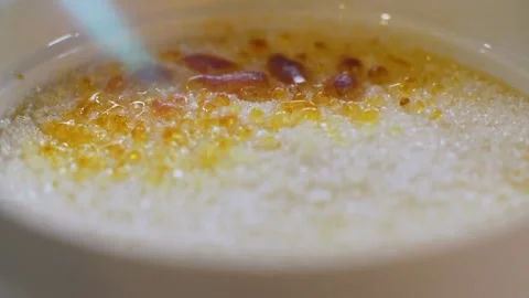 Kitchen torch caramelizing sugar on top of creme brulee Video stock 333836957