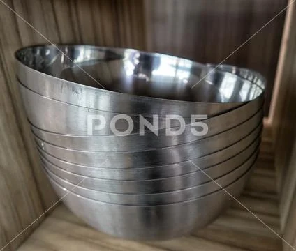Kitchen utensils and tableware on shelf. Group of stainless steel kitchenware Stock Photos